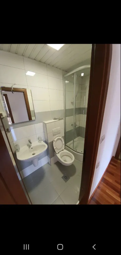 Svijetlo kupatilo sa tuš kabinom, lavaboom i WC šoljom.