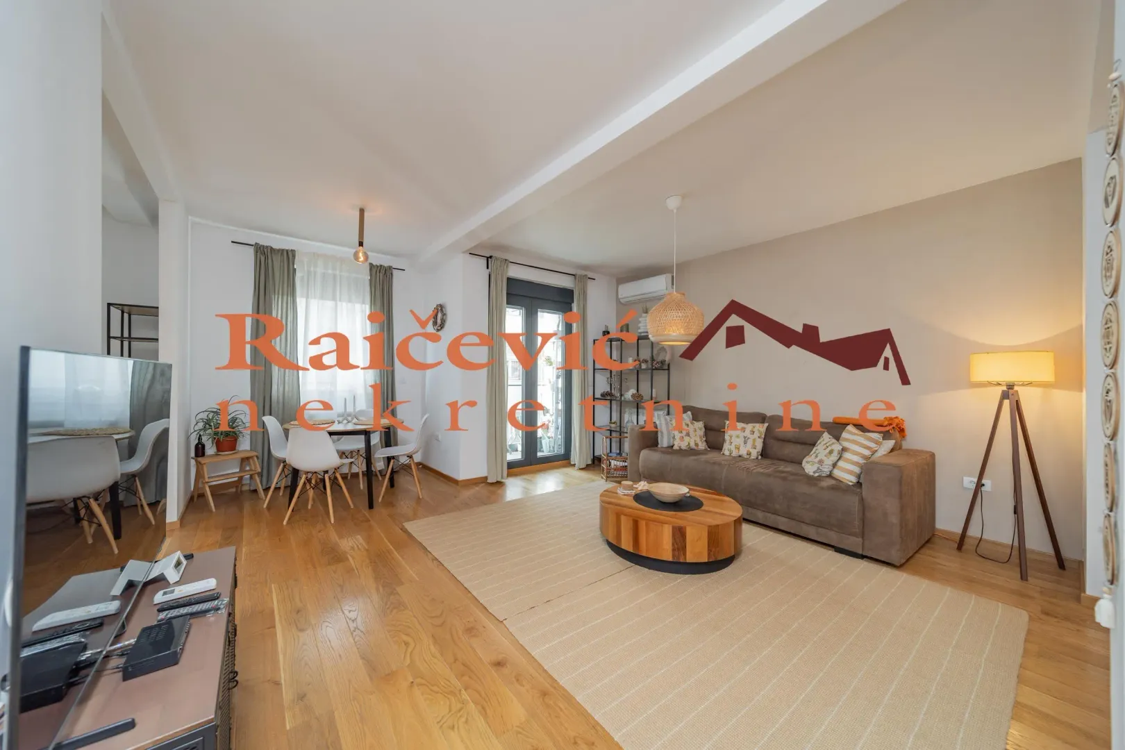 Living room with sofa, dining area, and access to the terrace.