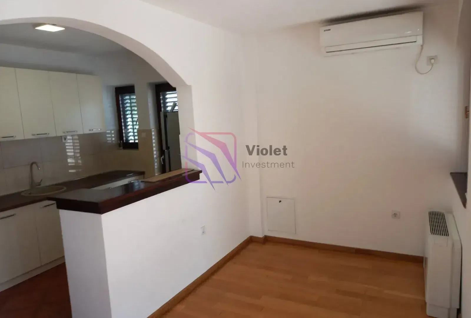 Dnevni boravak sa pogledom na kuhinju i šankom.