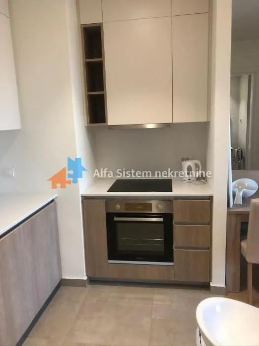 Small kitchen with built-in oven, hob, and wall cabinets.
