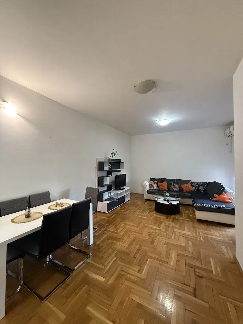 Spacious living room with a dining area and parquet flooring.