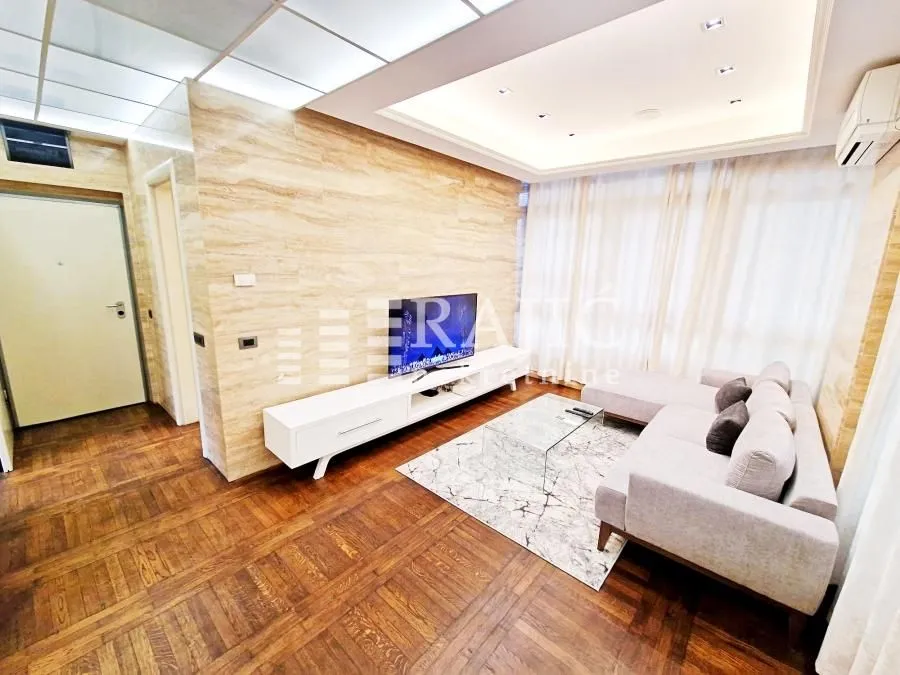 Modern living room with a sofa and parquet flooring.
