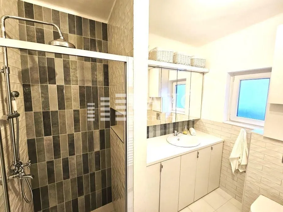 Modern bathroom with a shower cabin and a washbasin.