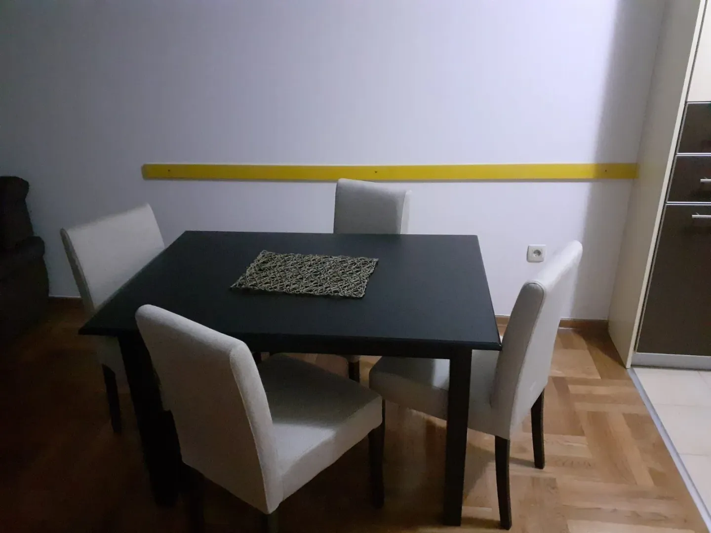 A dining table with four chairs.