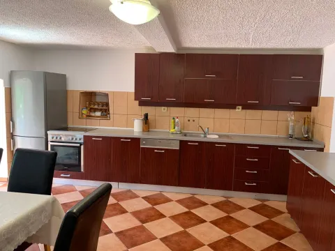 Kuhinja sa tamnim drvenim elementima i keramičkim pločicama na podu. - image 14