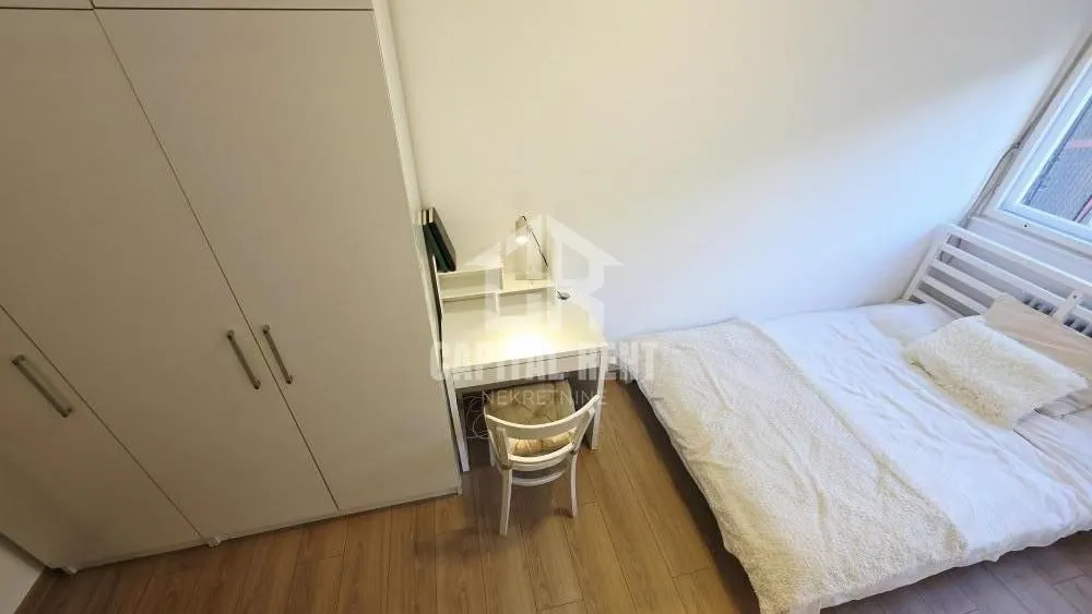Small bedroom with a bed, wardrobe, and desk.