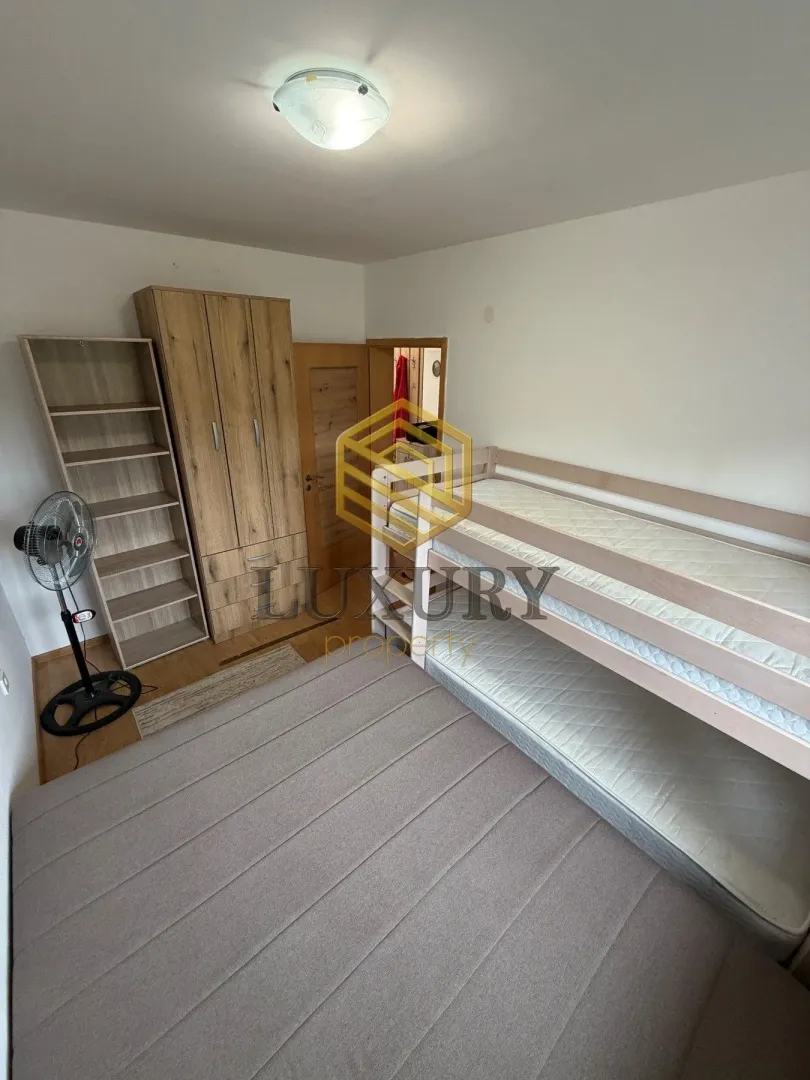 Children's bedroom with a bunk bed, wardrobe, and shelving unit.
