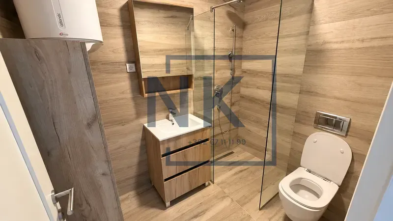 Moderne kupatilo sa drvenim pločicama, tuš kabinom i ugradnom šoljom.