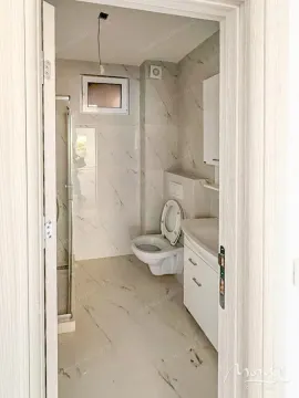 Pogled iz hodnika na moderno uređeno kupatilo sa tuš kabinom. - image 6