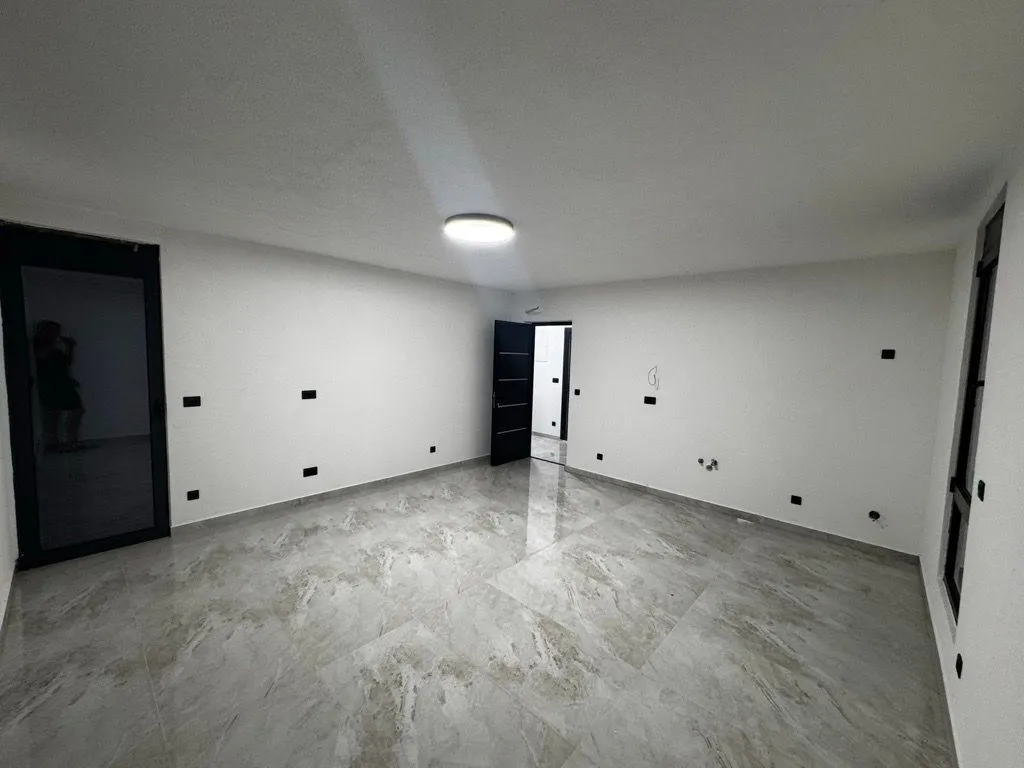 Empty room with light ceramic floor tiles.