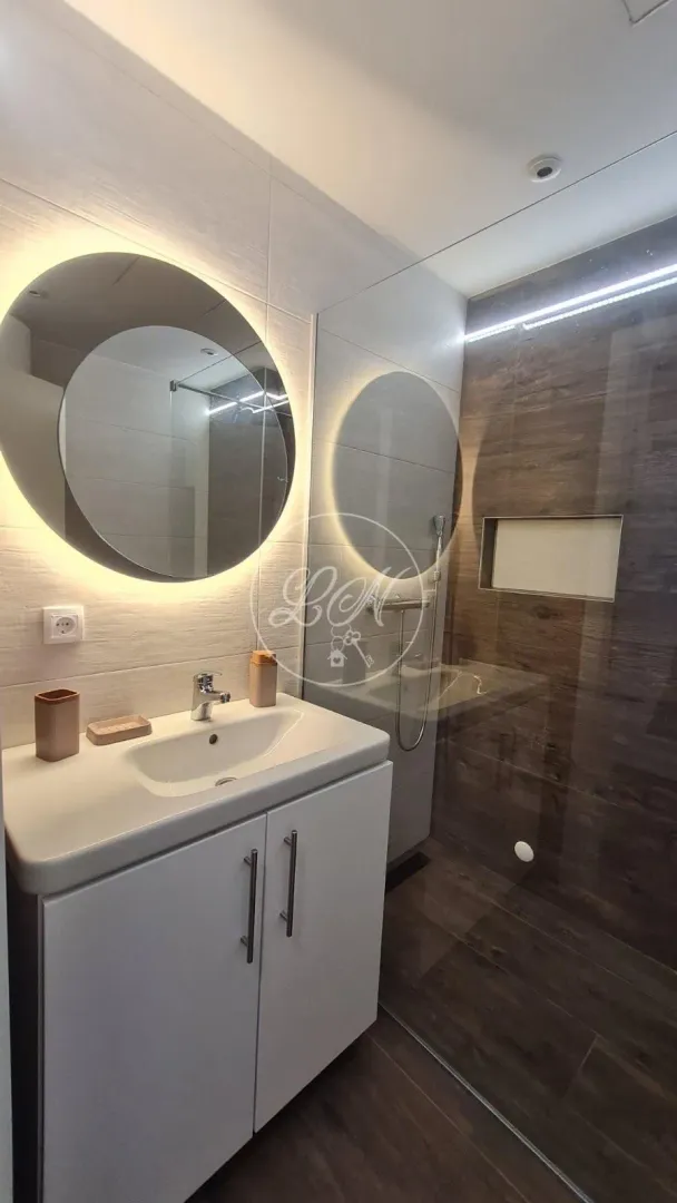 Modernly equipped bathroom with a washbasin and a walk-in shower.