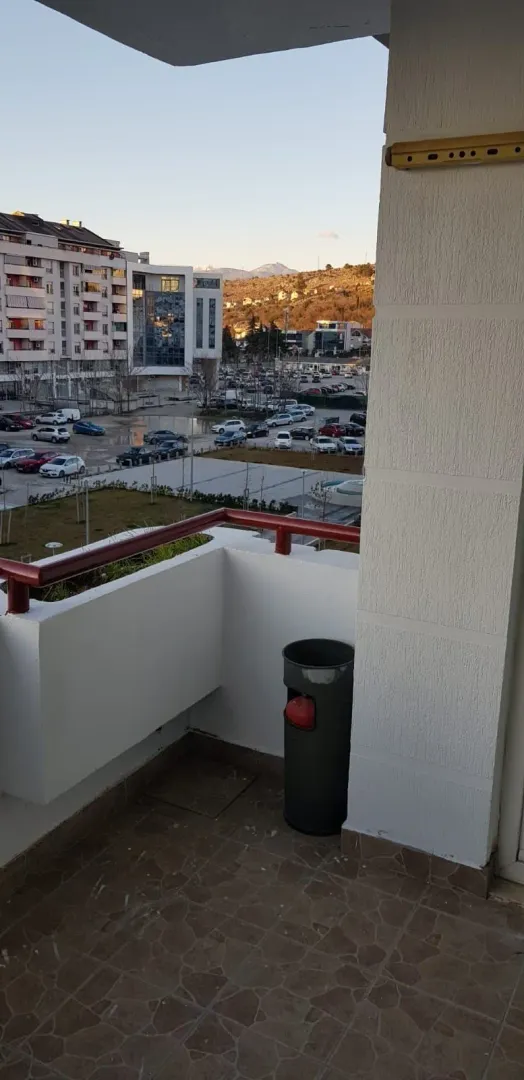 View from the balcony overlooking the urban neighborhood and parking area.