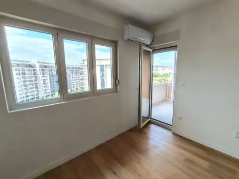 Prazna soba sa drvenim podom, prozorima i izlazom na terasu. - image 5