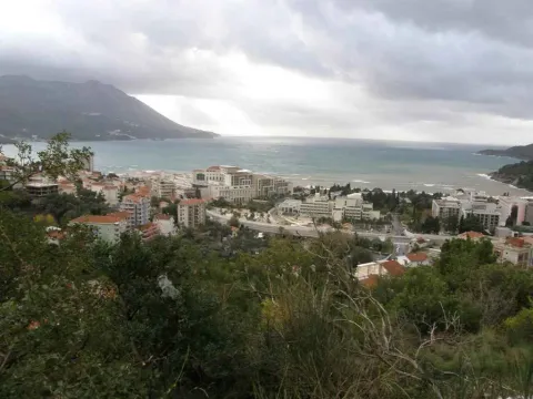 Pogled na more i grad sa uzvišenja pod oblačnim nebom. - image 6