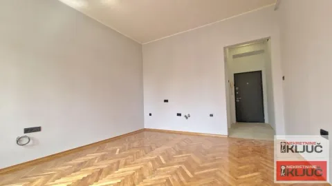 Prazna soba sa parketom i belim zidovima. - image 2