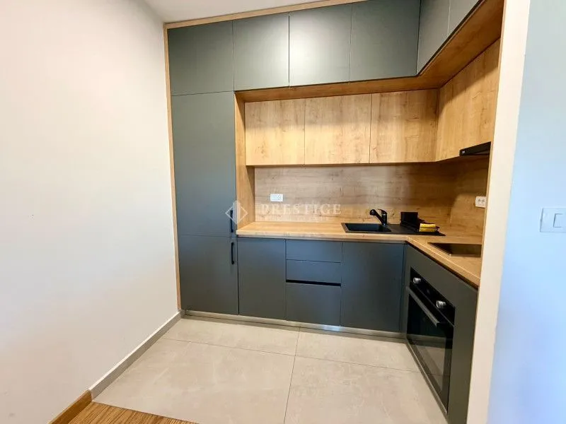 Modern kitchen with grey cabinets and wooden accents.