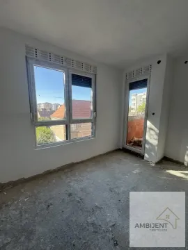 Prazna prostorija u izgradnji sa belim zidovima, prozorima i izlazom na terasu. - image 5