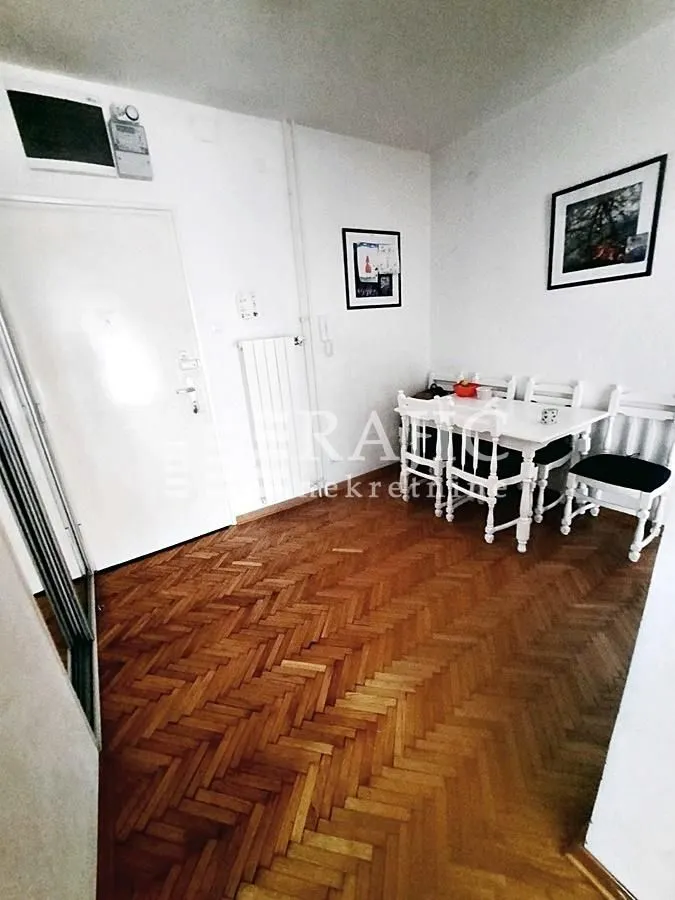 Living room with dining area and parquet flooring.