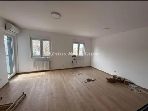 Prazna soba sa parketom, belim zidovima i dva prozora. - image 3