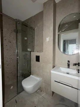 Novoopremljeno kupatilo sa tuš kabinom, umivaonikom i ugrađenom šoljom. - image 8