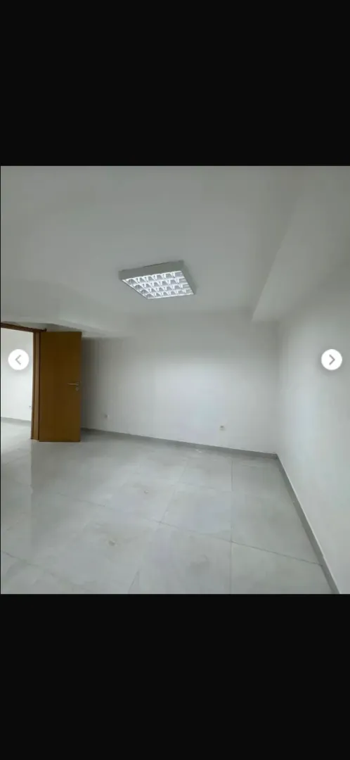 Empty bright room with tiled flooring and white walls.