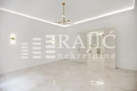 Empty living room with light floor tiles and a modern chandelier. - image 2