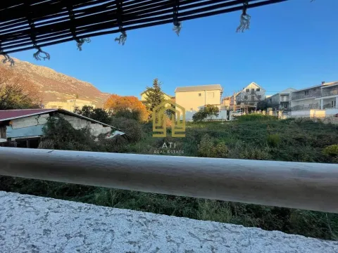 Pogled sa terase na dvorište i okolne kuće sa brdom u pozadini. - image 2