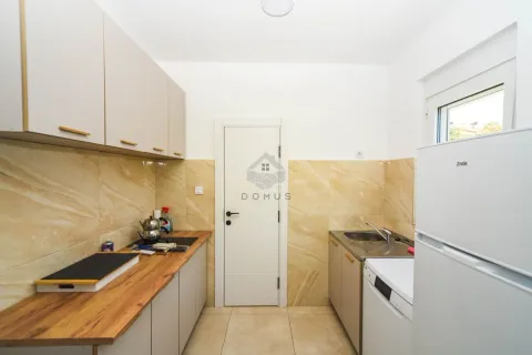 Small kitchen with wooden countertops, white cabinetry, and a refrigerator. - image 7