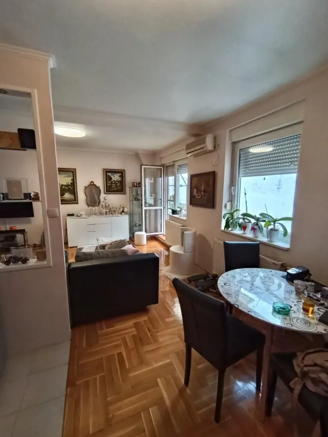Dnevna soba sa trpezarijom i parketom na podu.