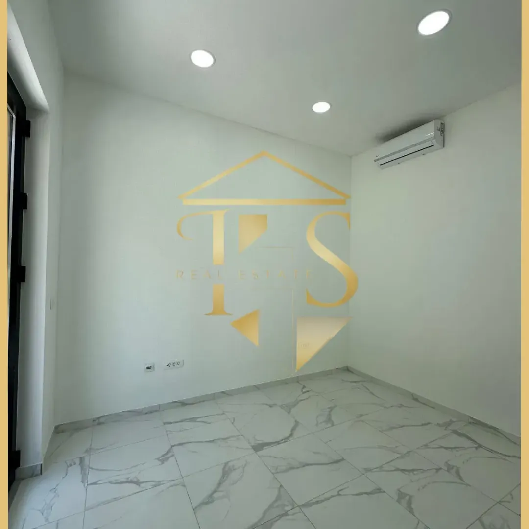 Empty bright room with ceramic floor tiles and an installed air conditioner.
