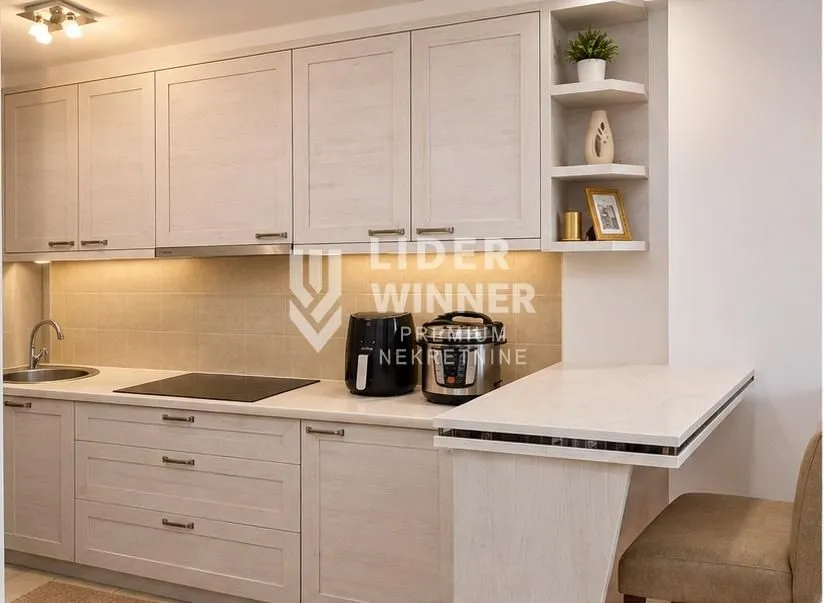 Kitchen with light wooden cabinetry and a small breakfast bar.