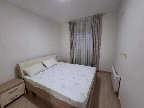 Furnished bedroom with a double bed and a window with curtains. - image 5