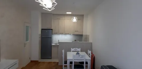 Bright kitchen with a small dining table and a refrigerator. - image 2