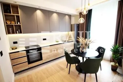 Modern kitchen with dining area and built-in appliances. - image 7
