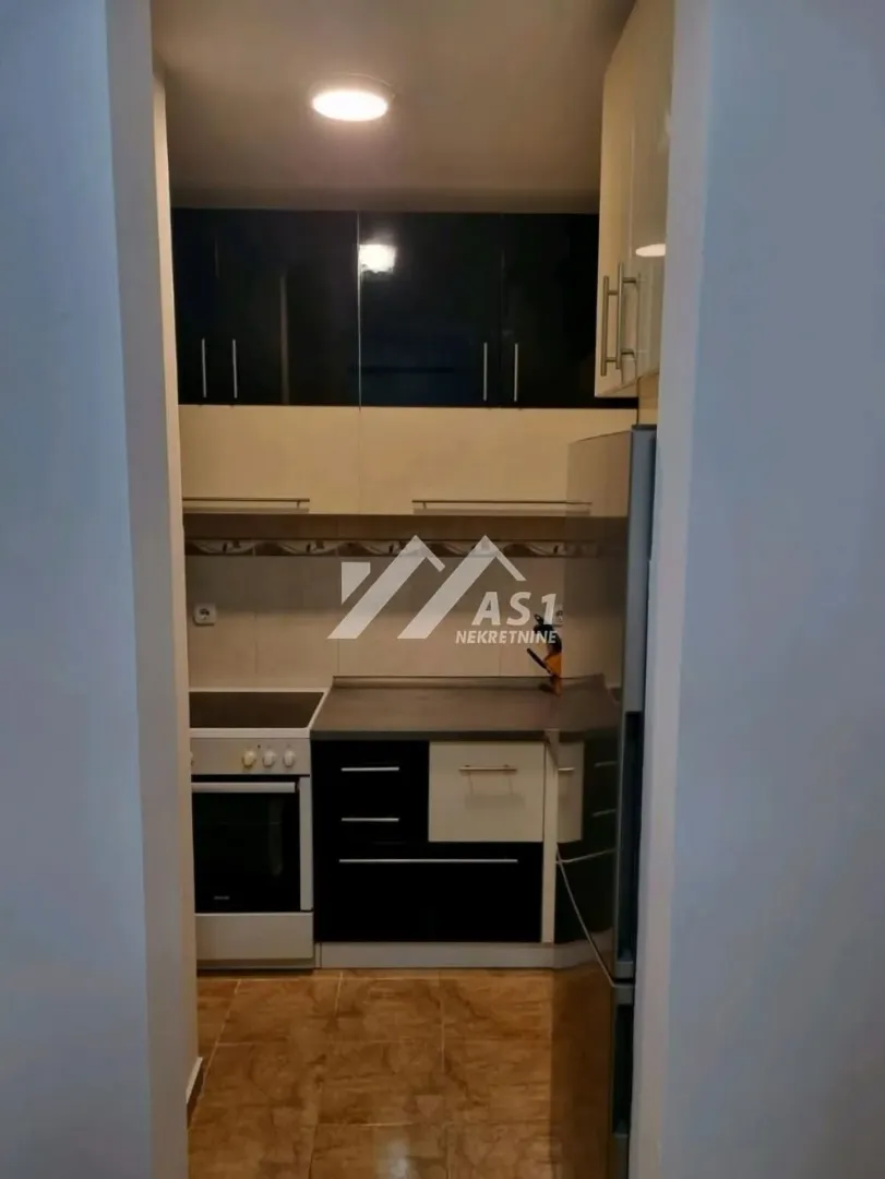 Smaller kitchen with cabinetry and built-in appliances.