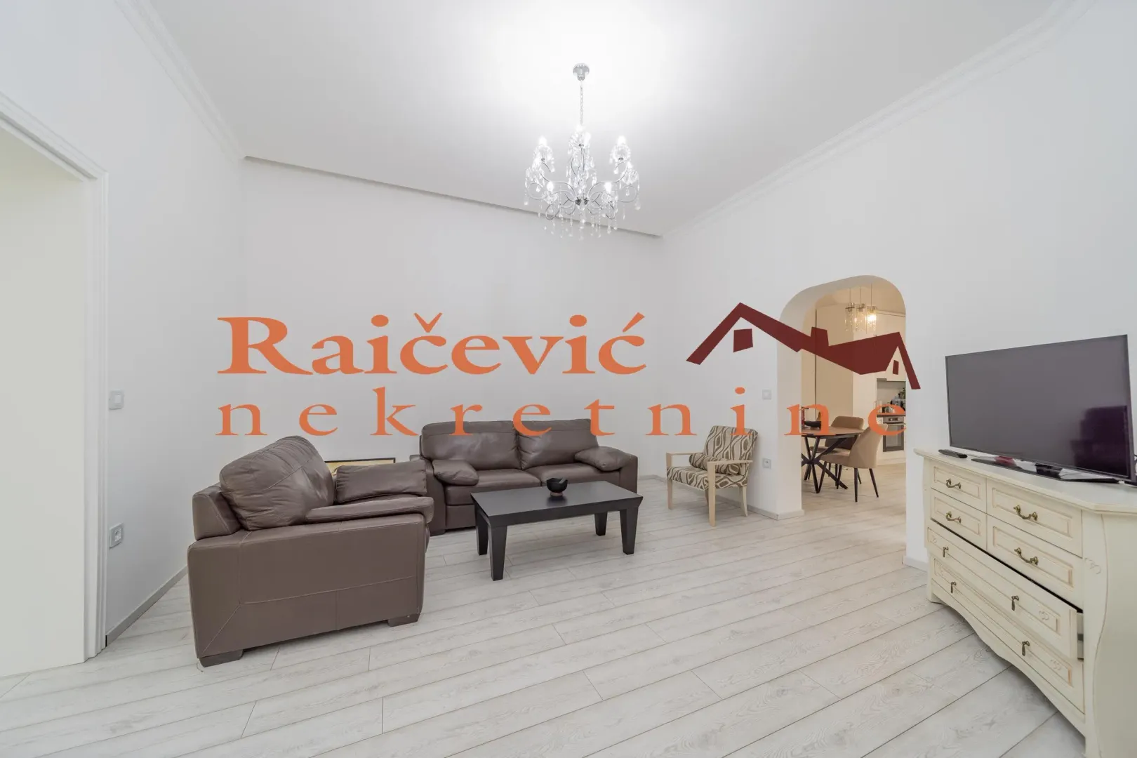 Spacious living room with seating set and TV.