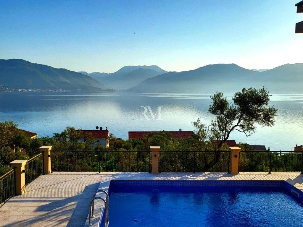 View of the sea and mountains from a terrace with a swimming pool.