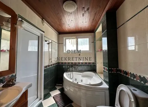 Bathroom with a corner whirlpool bathtub and wooden ceiling. - image 6