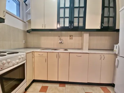 Small kitchen with light-colored cabinets, a sink, and a stove. - image 4