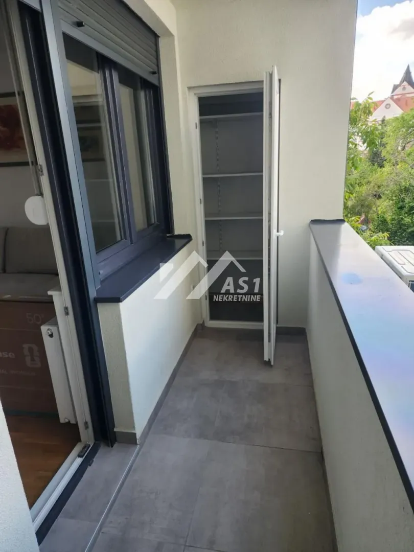 Balkon sa pločicama i ugradnim ormarom za skladištenje.