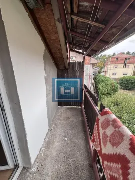 Natkriveni balkon sa drvenom ogradom i pogledom na okolinu. - image 19