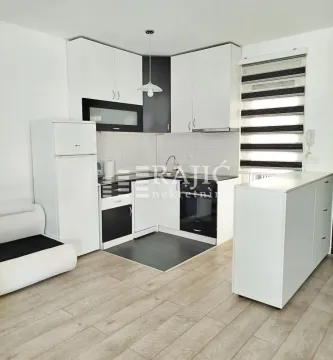 Small white kitchen with built-in appliances and a counter bar. - image 3