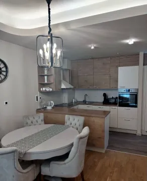 Modern kitchen with dining area and built-in appliances. - image 2