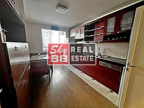 Long kitchen with dark wooden cabinets and a dining table in the background. - image 11