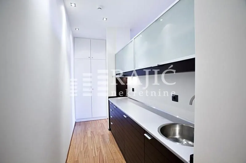 Modern kitchen with white upper cabinets and dark lower cabinets.
