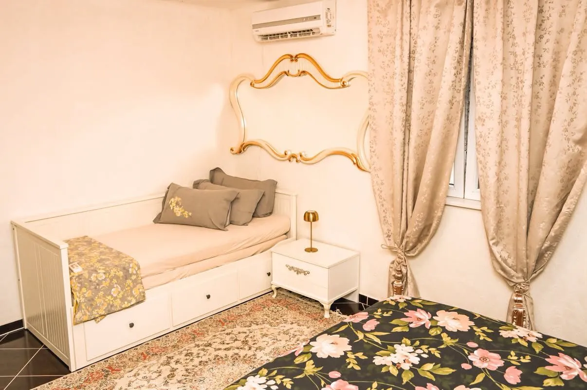 Furnished bedroom with a bed and a window with curtains.