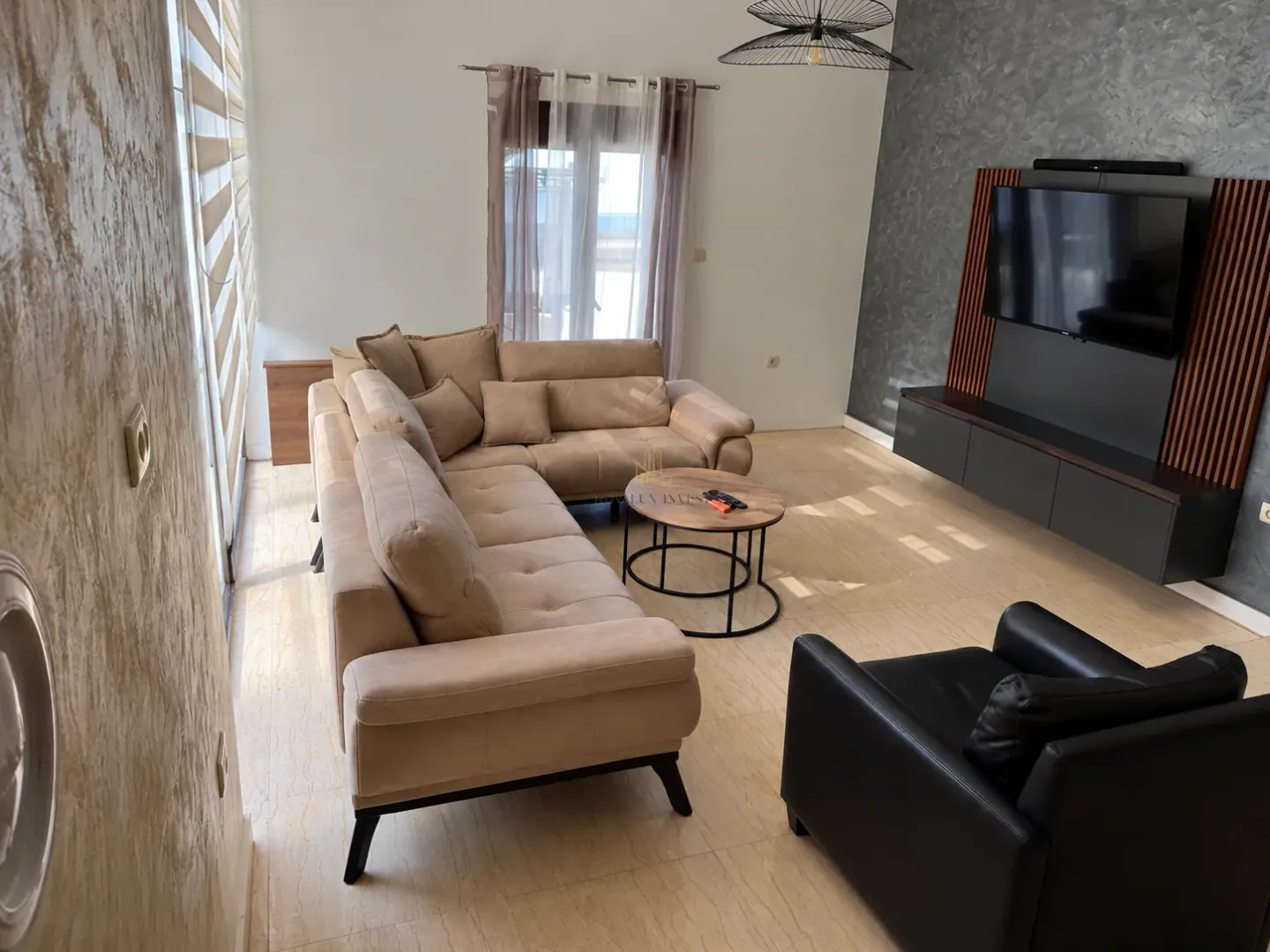Spacious living room with a sectional sofa, TV, and coffee table.