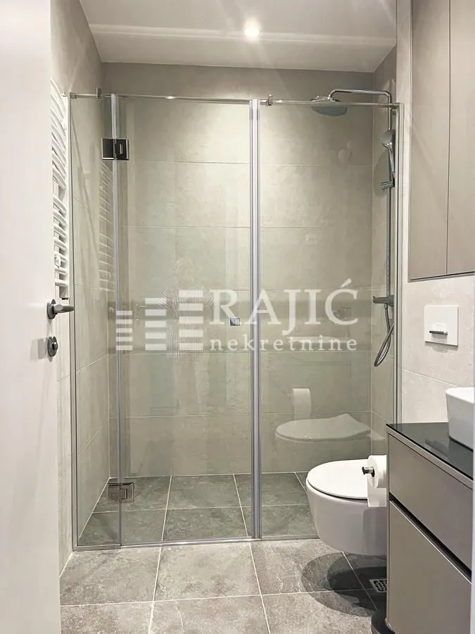 Modern bathroom with a walk-in shower and sanitary fixtures.