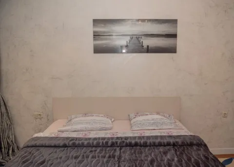 Furnished bedroom with a double bed and a decorative picture on the wall. - image 16