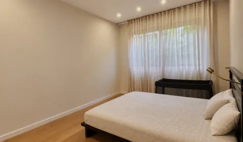 Bedroom with a double bed and a window covered with curtains. - image 9